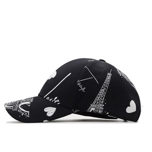 Black baseball cap with white Eiffel Tower and heart patterns on breathable fabric