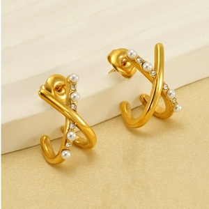 Detail of gold X-shaped earrings with alternating small pearls and sparkling zircons