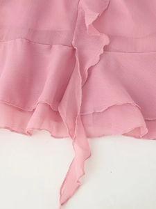 Detaillierte Nahaufnahme von rosa Schifffonstoff mit eleganten Rüschen und feiner Textur
