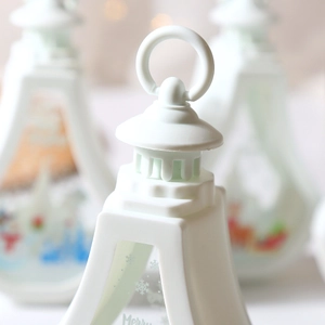 Close-up of white Christmas lantern top with hanging ring and snowflake patterns