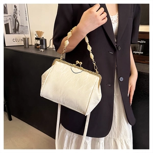 Detail of shell-shaped pearl handbag with floral embroidery and golden metal clasp
