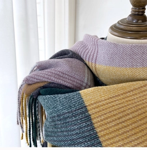 Detailed close-up of thick plaid tassel scarf with cashmere-like knitted texture