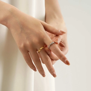 Close-up of gold twist and silver double-band titanium steel rings worn by a model