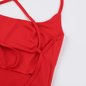 Detail of red sling dress showing cross-back thin straps and precise stitching texture