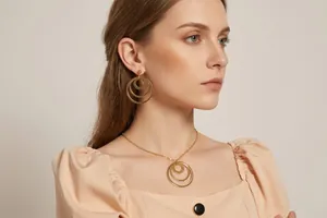 Golden interlocking triple circle necklace and earrings set worn by a fashion model