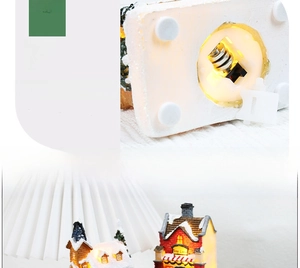 Detail of light-up resin Christmas house with snow effects and 3 button batteries