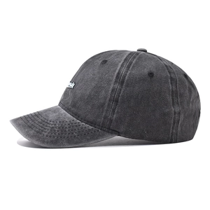 Close-up side view of washed vintage dark grey cotton baseball cap with letter embroidery