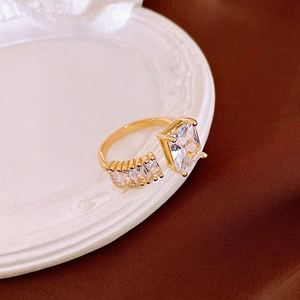 Detailed close-up of a gold butterfly ring featuring a large rectangular zircon stone