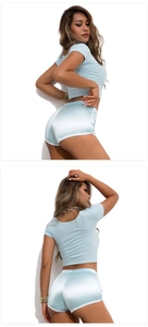 Detail of light blue slim fit yoga set featuring glossy satin fabric shorts and crop top