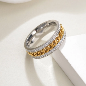 Détail macro de bague rotative en acier avec chaîne dorée et double rangée de zircons