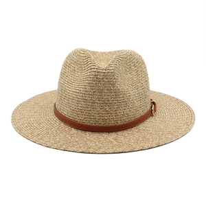 Detail of Panama straw hat showing fine weave texture and brown leather belt with gold buckle