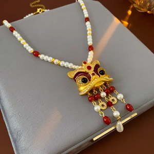 Dettaglio della collana vintage leone con perle, grani rossi e nappe di monete oro