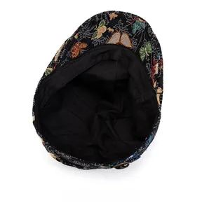 Detailansicht der bunten Schmetterlingsstickerei und des Innenfutters der Baskenmütze