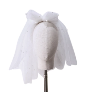 Short double-layer white bridal veil with pearls and a large bow on mannequin