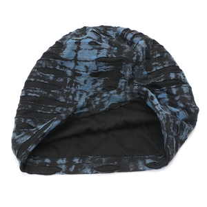 Detail of distressed knit beanie with blue tie-dye pattern and ripped hole texture