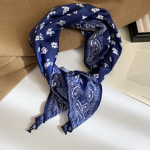 Detailed macro of silk scarf necklace featuring blue paisley patterns and soft texture