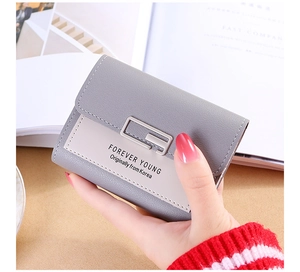 Detailed macro view of litchi texture leather and silver buckle on a tri-fold wallet