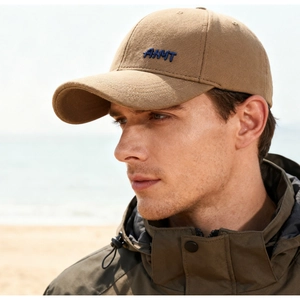 Close-up of embroidered AMMT logo on brown wool baseball cap with outdoor styling