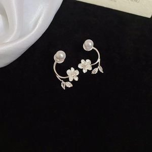 Detail of silver flower stud earrings with pearls and crystal leaves on black velvet