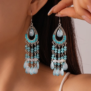 Detail of bohemian silver hook earrings featuring sky blue crystal tassels and water drop gems