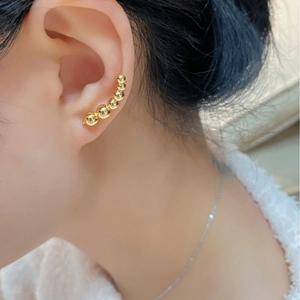 Close-up of a model wearing minimalist golden gradient beads ear crawler along the earlobe
