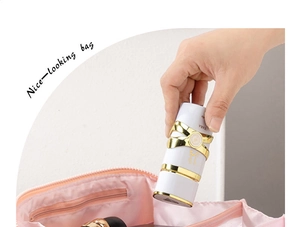 Pink portable travel makeup bag with internal zipper compartment and perfume bottle