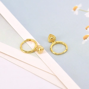 Elegant gold heart pendant earrings on a minimalist blue and white aesthetic background
