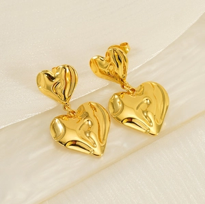 Detail of gold double layered heart earrings with molten lava textured liquid metal finish