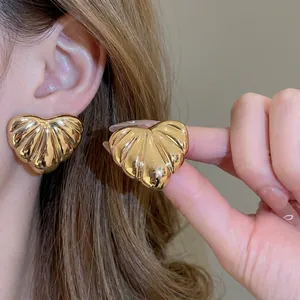Golden heart earrings with shell texture pattern for women in a luxury aesthetic
