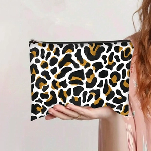 Close-up of leopard print canvas makeup bag with durable black zipper closure in hand