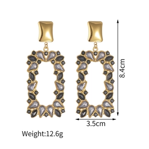Detailed view of large gold-tone tiered rectangular earrings with grey rhinestones