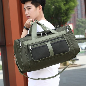 Large green foldable travel duffel bag with shoulder strap shown in an outdoor street setting