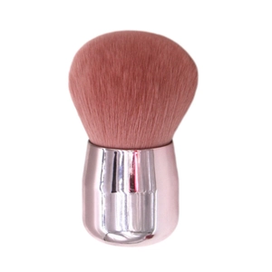Close-up of pink fluffy bristles and reflective rose gold handle on large makeup brush