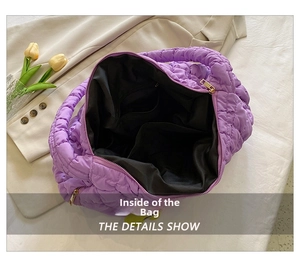 Detail view of the purple quilted tote bag internal pockets and spacious black lining
