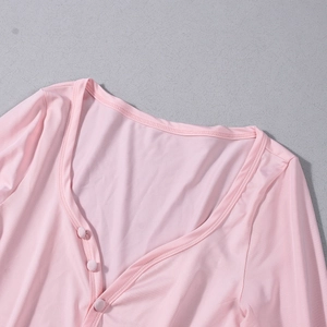 Vue détaillée du haut en maille rose avec décolleté en V profond et boutons assortis