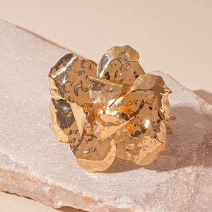 Detailed close-up of golden irregular wrinkled flower cuff with hammered metal texture