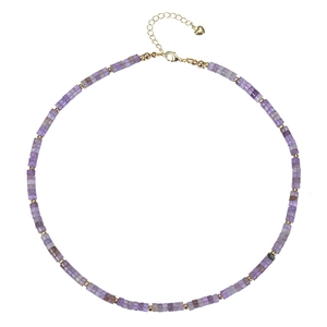 Detailed view of bohemian purple beaded necklace with gold spacers and heart charm pendant