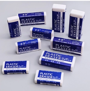 Scattered layout of soft 2B plastic erasers for students on a neutral grey background