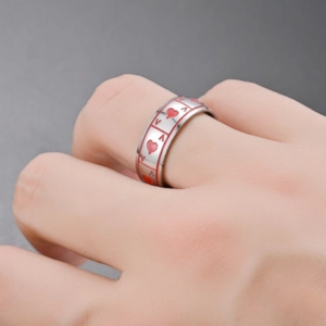 Close-up of titanium steel ring with red Ace of Hearts playing card design.