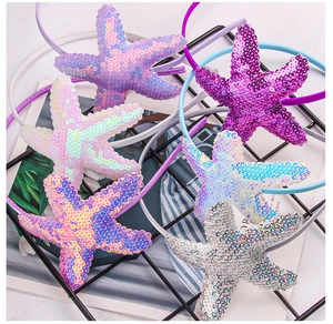 Close-up of sparkling sequin starfish headbands in purple, pink, blue and silver colors