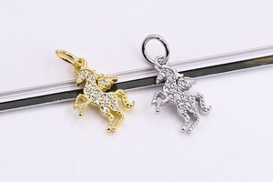 Dettaglio di ciondoli a unicorno in argento e oro con zirconi micro-pave e ali