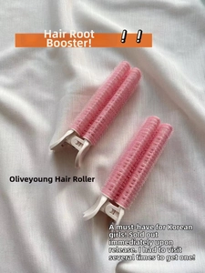 Close-up of pink hair root clips on white fabric for volumizing and styling hair