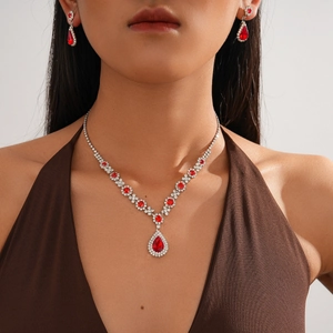 Macro shot of silver jewelry set with red teardrop gems and crystal halo details