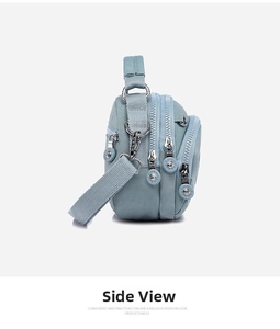 Detail view of the multi-layer compartments and blue-grey nylon fabric on this crossbody bag