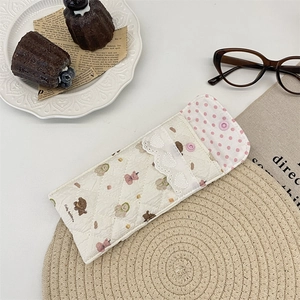 Detail of quilted cartoon bear glasses pouch with lace trim and pink polka dot lining
