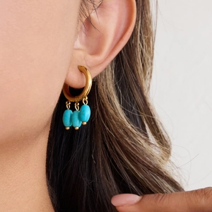 Detail of 18k gold plated hoop earring with three blue turquoise-style dangling beads