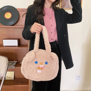 Detail of cute beige lamb wool handbag featuring a cartoon animal embroidery and soft texture