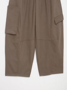 Détails du pantalon cargo marron montrant le tissu sergé et la poche latérale pratique