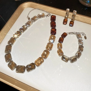 Macro shot of silver jewelry set with amber and clear rectangular crystals on a display