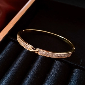 Détail d'un bracelet jonc plaqué or 18 carats avec micro-pavage de zircone sur satin noir